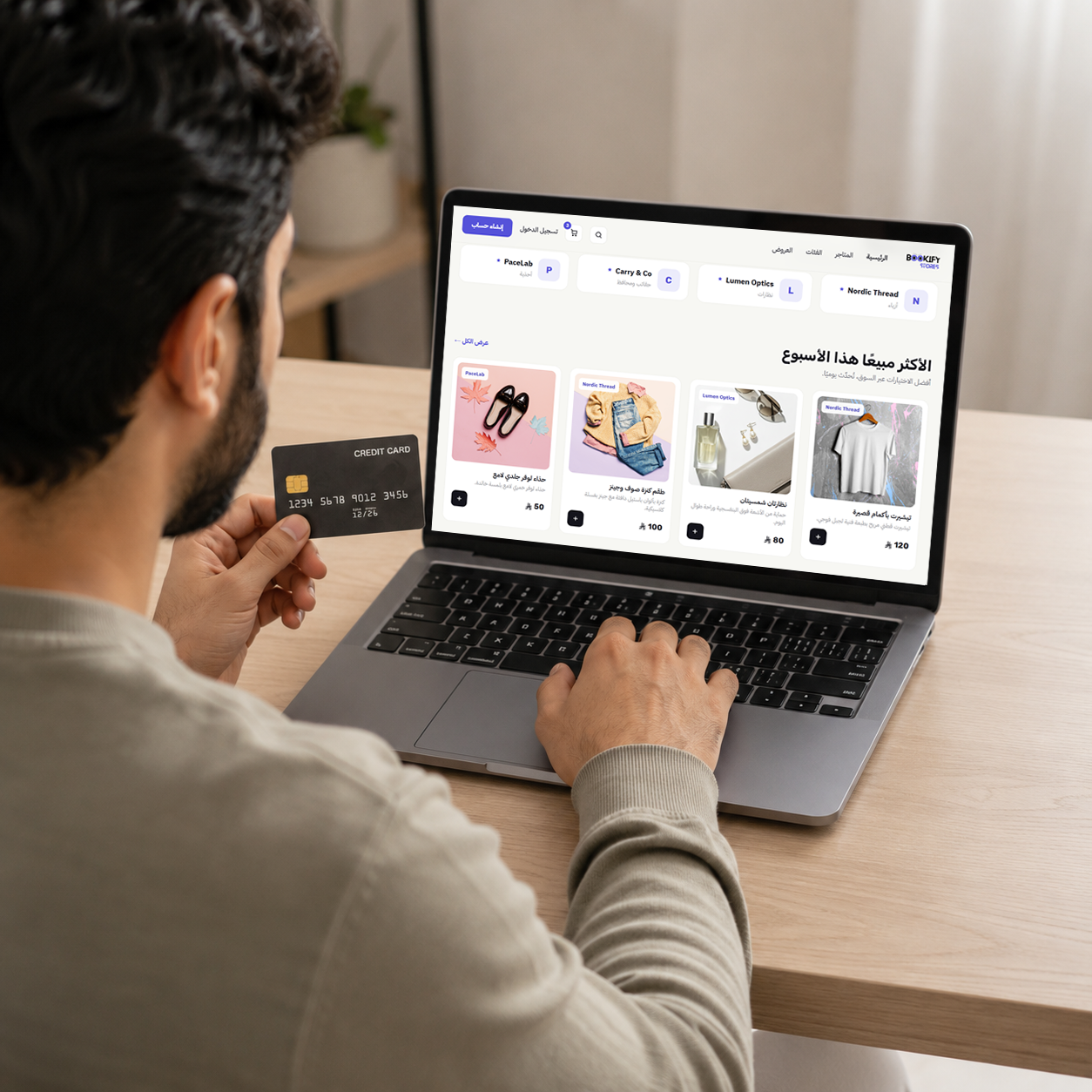 A shopper browsing the Bookify Stores marketplace on a laptop with a card in hand
